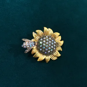 Close-up detail of vintage gold sunflower and sparkling bee brooch, exquisite alloy rhinestone decor.