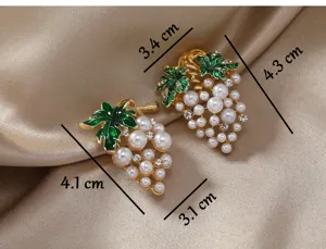 Creative grape brooch pin featuring green enamel leaves, white pearls and sparkling rhinestones.