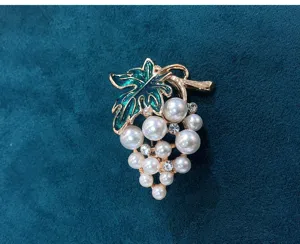 Detail shot of cute grape brooch with faux pearls, rhinestones, and green enamel leaves.