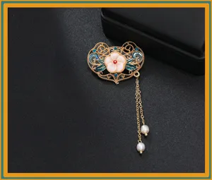 Nahaufnahme einer traditionellen chinesischen Emaille-Blumen-Brosche mit Perlenquasten.