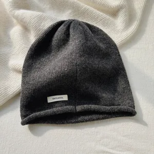 Gorro de punto de lana gris oscuro primer plano, vista detallada textura invierno suave.