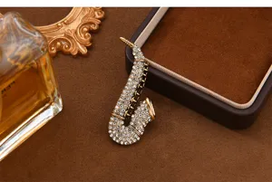 Vintage rhinestone saxophone brooch detail, elegant music instrument pin for women.