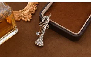 Vintage trumpet brooch pin featuring shimmering rhinestones and antique bronze metal finish.