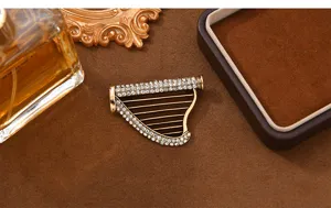 Vintage harp brooch pin with sparkling rhinestones, elegant bronze musical instrument jewelry.