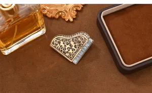 Close-up view of the vintage piano brooch with sparkling rhinestones and detailed design.