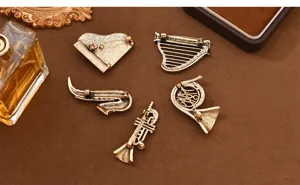 Detailed view of vintage musical instrument brooch backs showing secure pins and metal texture.