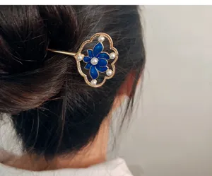 Gros plan détaillé du bâton de cheveux lotus bleu rétro avec émail et décorations de perles.