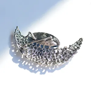 Detail view of the back pin mechanism and mesh texture of the vintage crescent brooch.