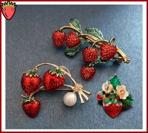Close-up detail van schattige aardbei emaille broches met parel voor leuke kleding decoratie.