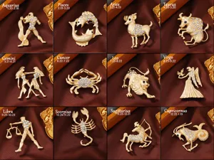 Set of twelve zodiac sign brooches featuring matte gold finish and sparkling crystal rhinestones.