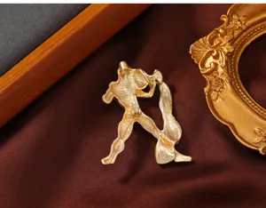 Detailed view of matte gold creative brooch back design, showing pin mechanism and fine texture.