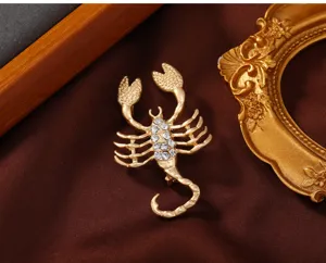 Matte gold scorpion brooch with sparkling rhinestones, exquisite clothing accessory detail.