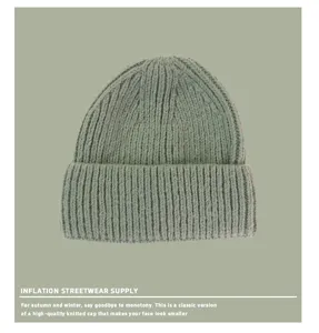 Gros plan détaillé montrant la texture en tricot côtelé vert sauge de ce bonnet chaud
