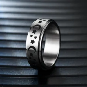 Detalle de cerca de anillo giratorio de acero con grabado de estrellas y lunas