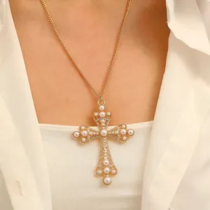 Elegant gold plated cross pendant necklace with pearls shown on a white shirt model