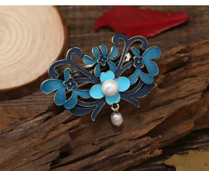 Detailed close-up of retro blue enameled floral hair barrette with elegant freshwater pearl drops.