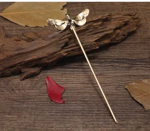 Detailed shot of the vintage dragonfly metal hair stick, elegant bronze finish retro design.