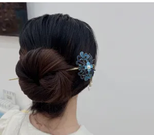 Detail shot of traditional Chinese style blue enamel floral hair stick with pearl tassels.