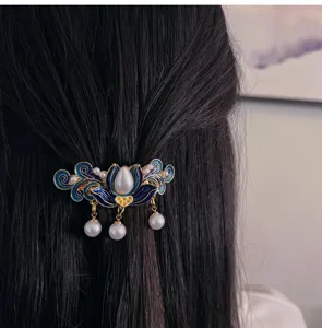 Vue détaillée de la pince à cheveux à pampilles en émail avec motif floral et perles.