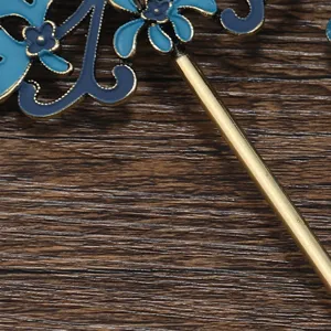 Cloisonne floral hair accessory detail view showing exquisite blue enamel flower and golden shaft.