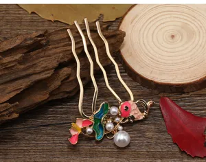 Gros plan détaillé du peigne à cheveux vintage poisson émaillé avec perles pour style traditionnel.