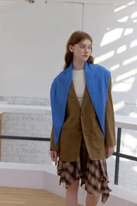 Foto de detalle de bufanda triangular de punto azul que muestra moda de otoño elegante y cómoda.