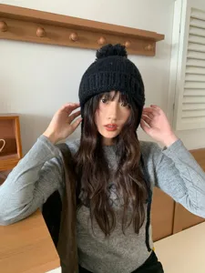 Gorro de punto negro con pompón, vista detallada suave y cómoda para la temporada de invierno.
