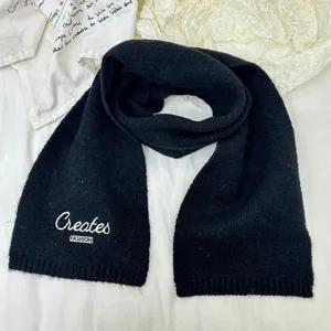 Detailansicht des schwarzen Kinder-Strickschals mit weißem besticktem Text für warme Winter.