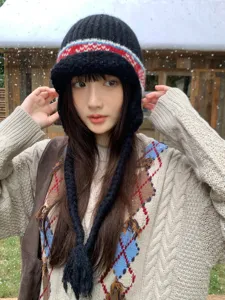 Close-up detail of a cozy black knit ear-flap hat with Fair Isle winter jacquard pattern.
