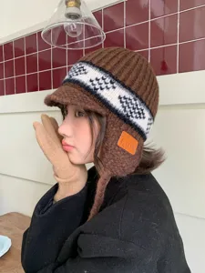 Detail view of the brown knitted trapper hat featuring classic fair isle patterns and cozy earflaps.
