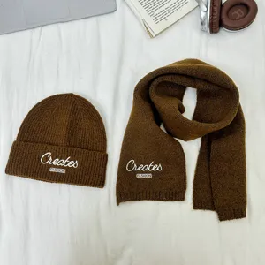 Detailansicht des braunen Kinder Strickmützen und Schal Sets mit modischer Stickerei.