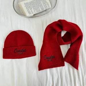 Rote Strickmütze und Schal Set Detail, kuschelige Winteraccessoires für Kinder mit Stickerei.