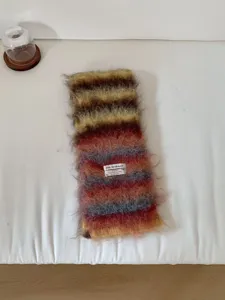 Nahaufnahme der kuscheligen, flauschigen gestreiften Strickschals, weiches Wintermaterial.