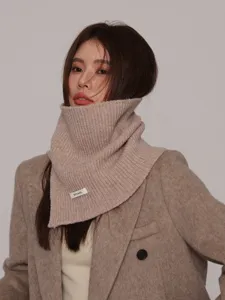 Detalle de cerca de un calentador de cuello de punto beige, accesorio de moda de invierno.