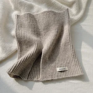 Vista detallada del acogedor calentador de cuello de punto con textura acanalada suave y lana.