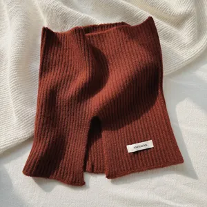 Vista detallada del cuello tejido de lana rojo oscuro, con textura suave y estilo cómodo y abrigado.