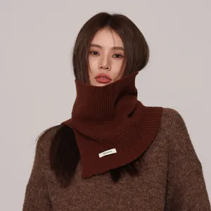 Primer plano detallado de un acogedor cuello alto de punto marrón con textura de lana suave.