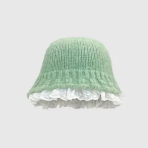 Vue détaillée du chapeau seau en tricot vert clair avec bordure en dentelle blanche délicate.