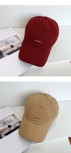 Primo piano di cappelli da baseball morbidi e casual in bordeaux e khaki con scritta.