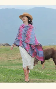 Colorful chevron patterned ethnic cape detail shot showcasing cozy outdoor travel style and warm texture.