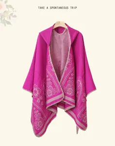 Ethnic paisley print hooded knitted cape detail showing exquisite tassel pattern and cozy fabric.