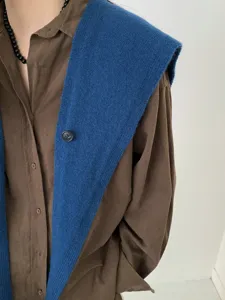 Elegant blue knitted shawl paired with brown shirt, stylish and warm women's winter cape accessory.