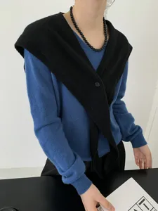 Detail view of the elegant wool crossover pointed shawl and blue knit sweater, stylish look.