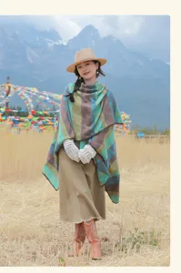 Scenic travel style shot showing the colorful chevron patterned warm poncho shawl outdoor details.