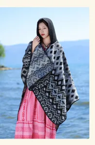 Detail shot of the geometric hooded knitted poncho cloak showing unique ethnic pattern texture.