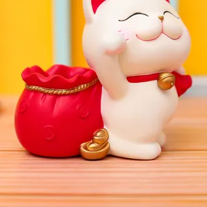 Cute lucky cat resin pen holder detail, showing exquisite red money bag and gold ingot craft.