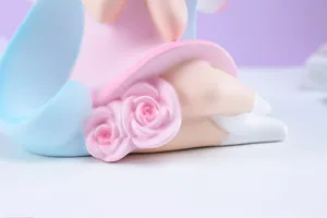 Gros plan sur les détails de la tirelire fée des fleurs, résine rose et bleue cadeau.