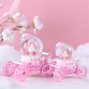 Détail de boule à neige carrosse rose, jolie poupée animée dedans, décor romantique.