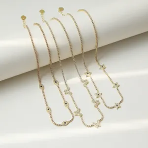 Gros plan détaillé de colliers tennis en zircone cubique multi-brins avec des breloques œil et papillon.
