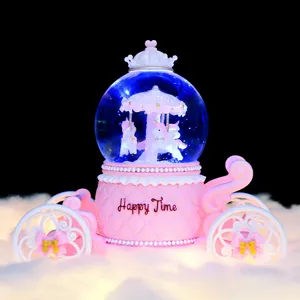 Closeup detail of the pink carriage snow globe featuring rotating carousel unicorns and lights.